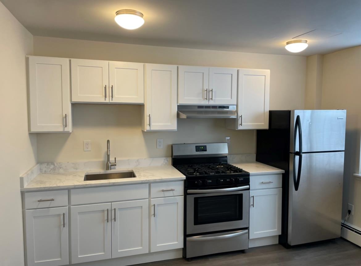 a kitchen with white cabinets and stainless steel appliances