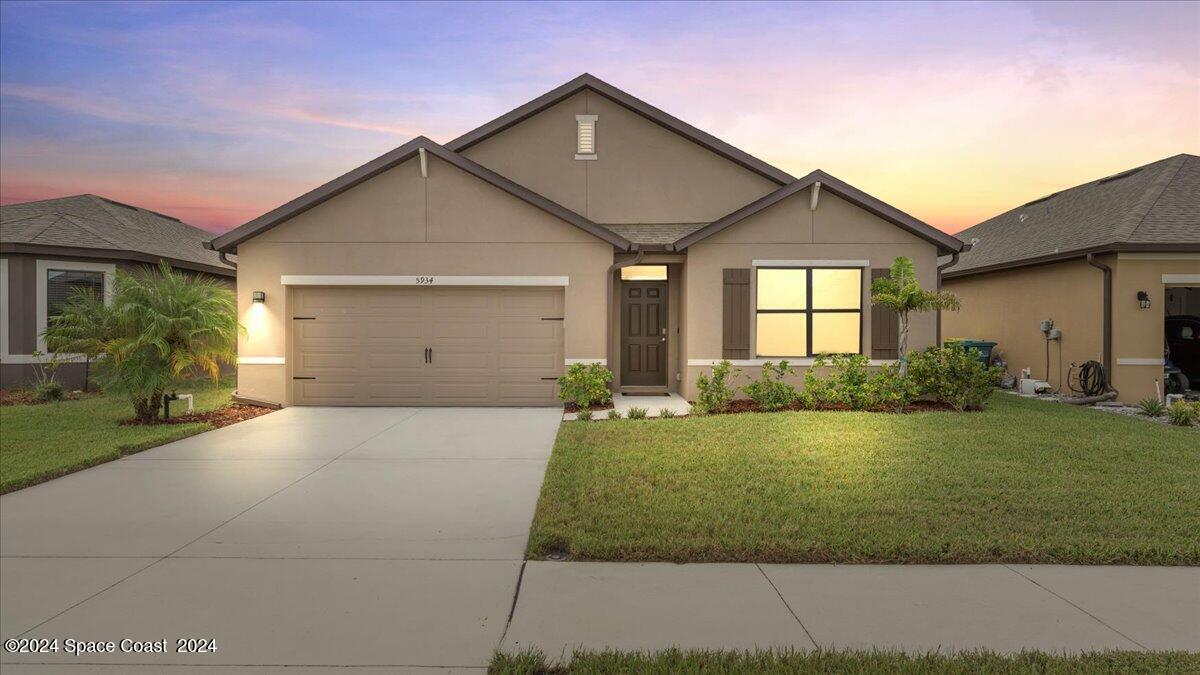 a front view of a house with a yard and garage