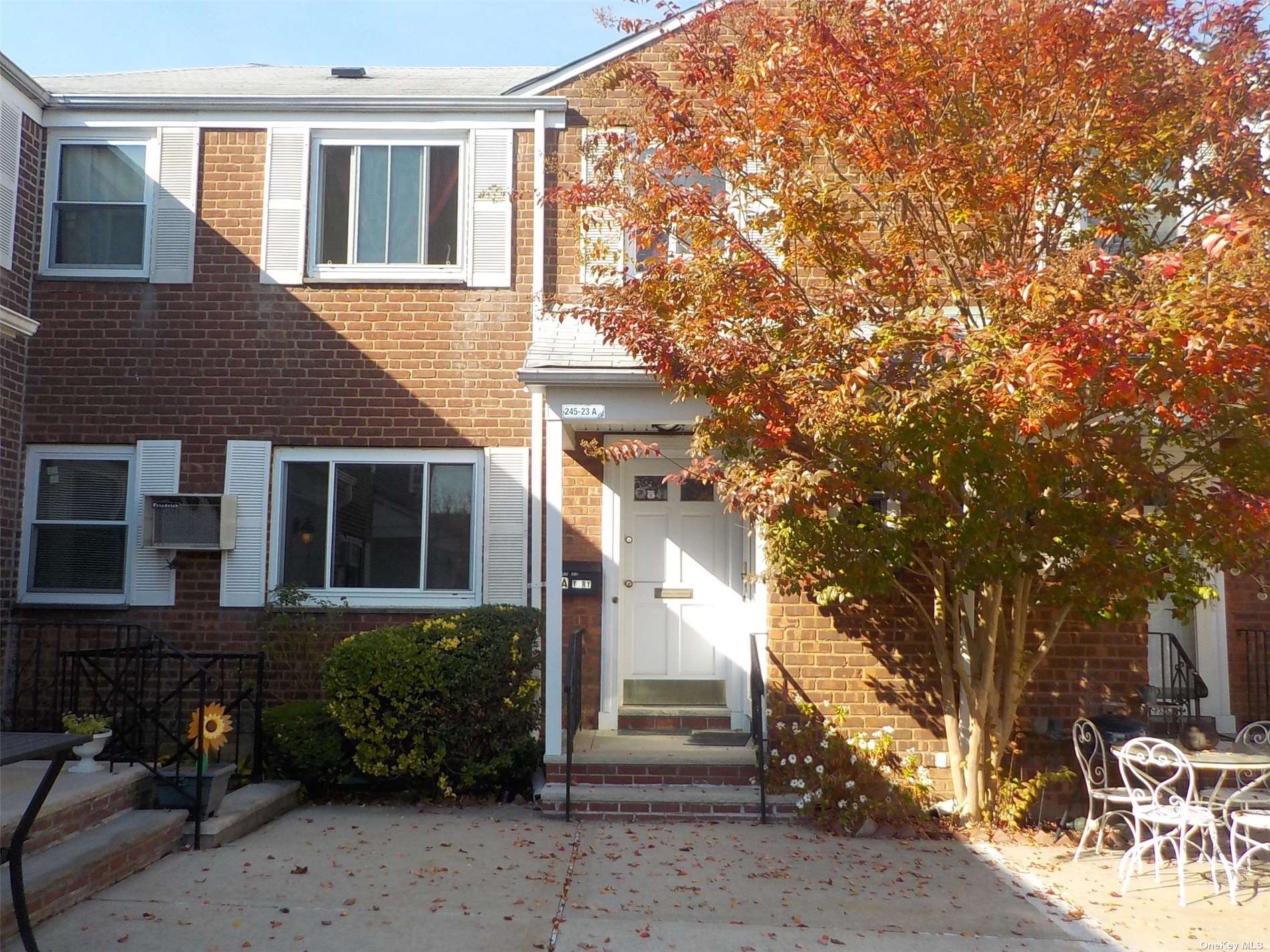 a front view of a house with a tree