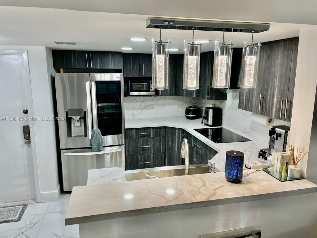 a kitchen with stainless steel appliances a sink and a refrigerator