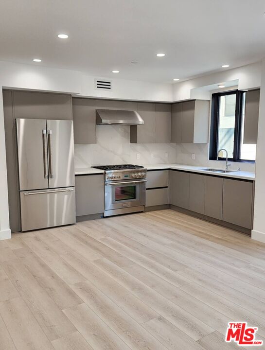 a large kitchen with stainless steel appliances granite countertop a large counter top and a stove top oven