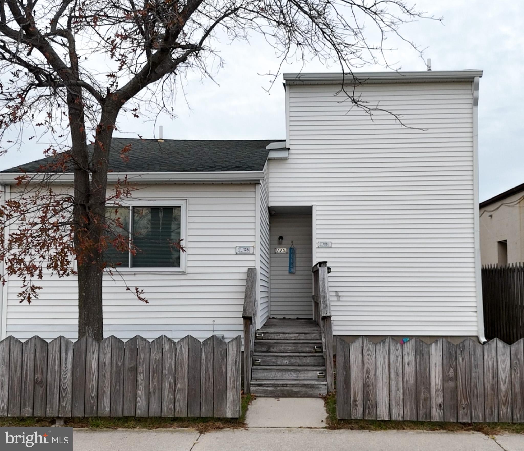 a view of a house with a house and wooden fence