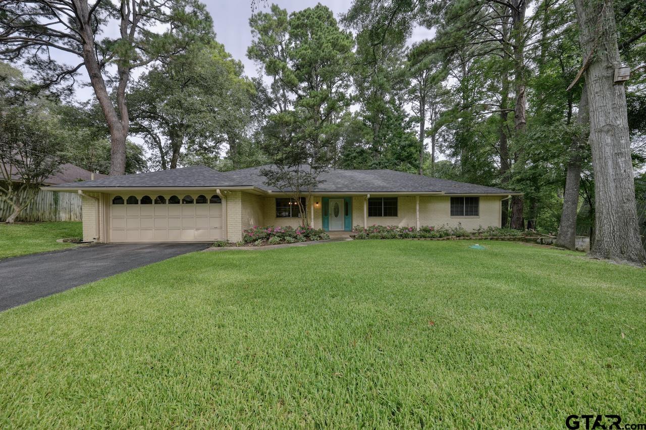 a front view of a house with a yard and lake view