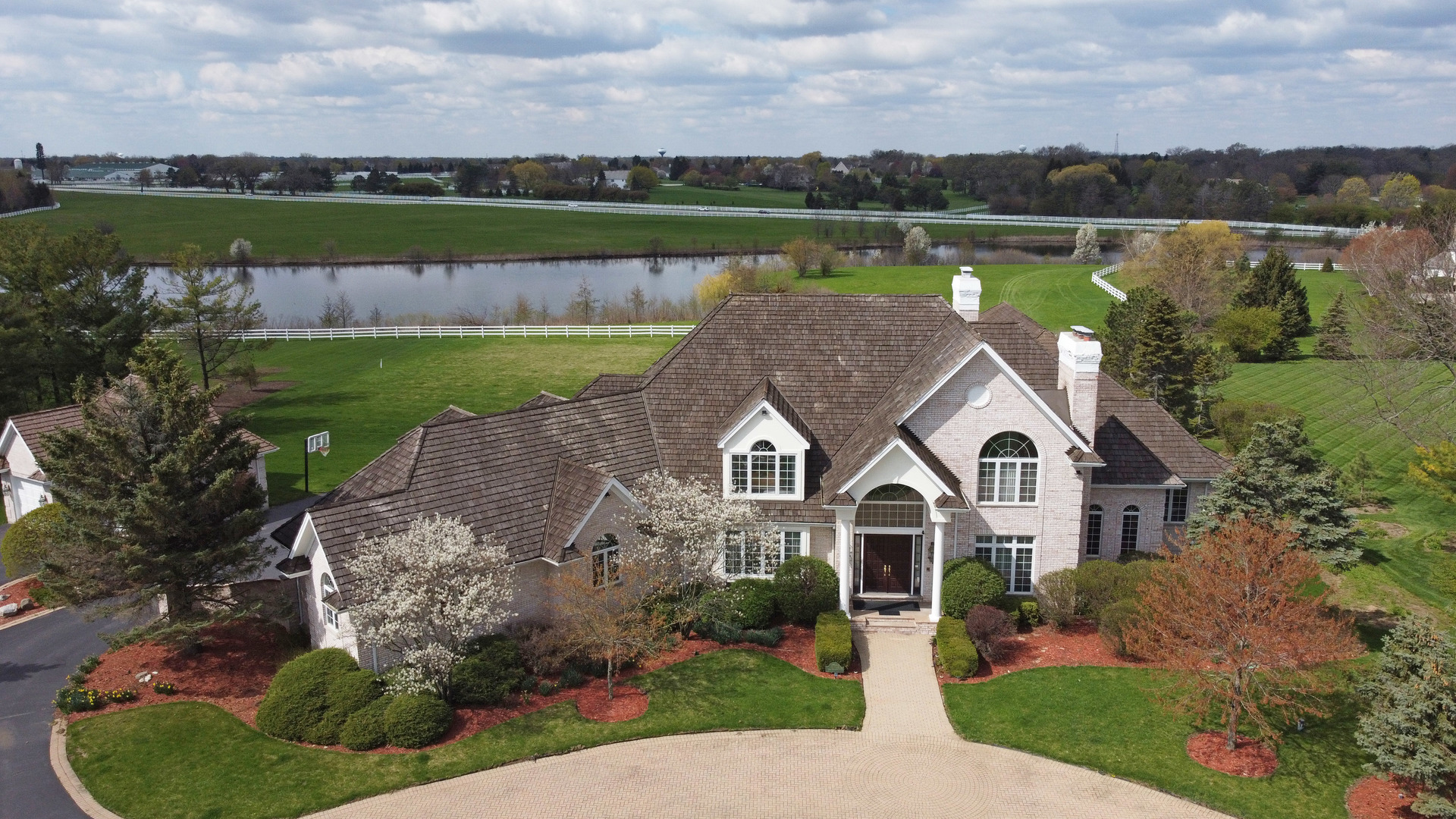 an aerial view of a house with a yard and lake view