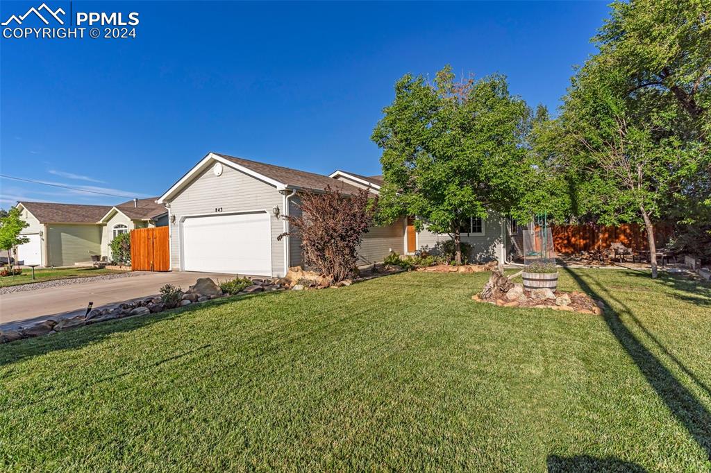 View of front of house with a garage and a front yard