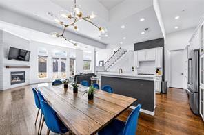 a view of a dining room and livingroom with furniture wooden floor a chandelier