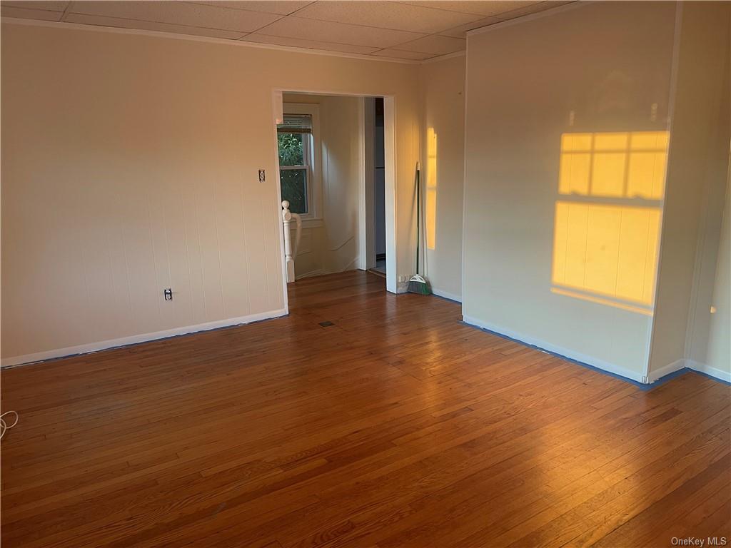 Spare room with hardwood / wood-style flooring and a drop ceiling