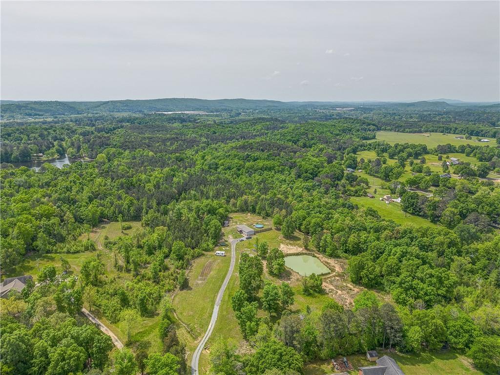 an aerial view of residential houses with outdoor space and trees