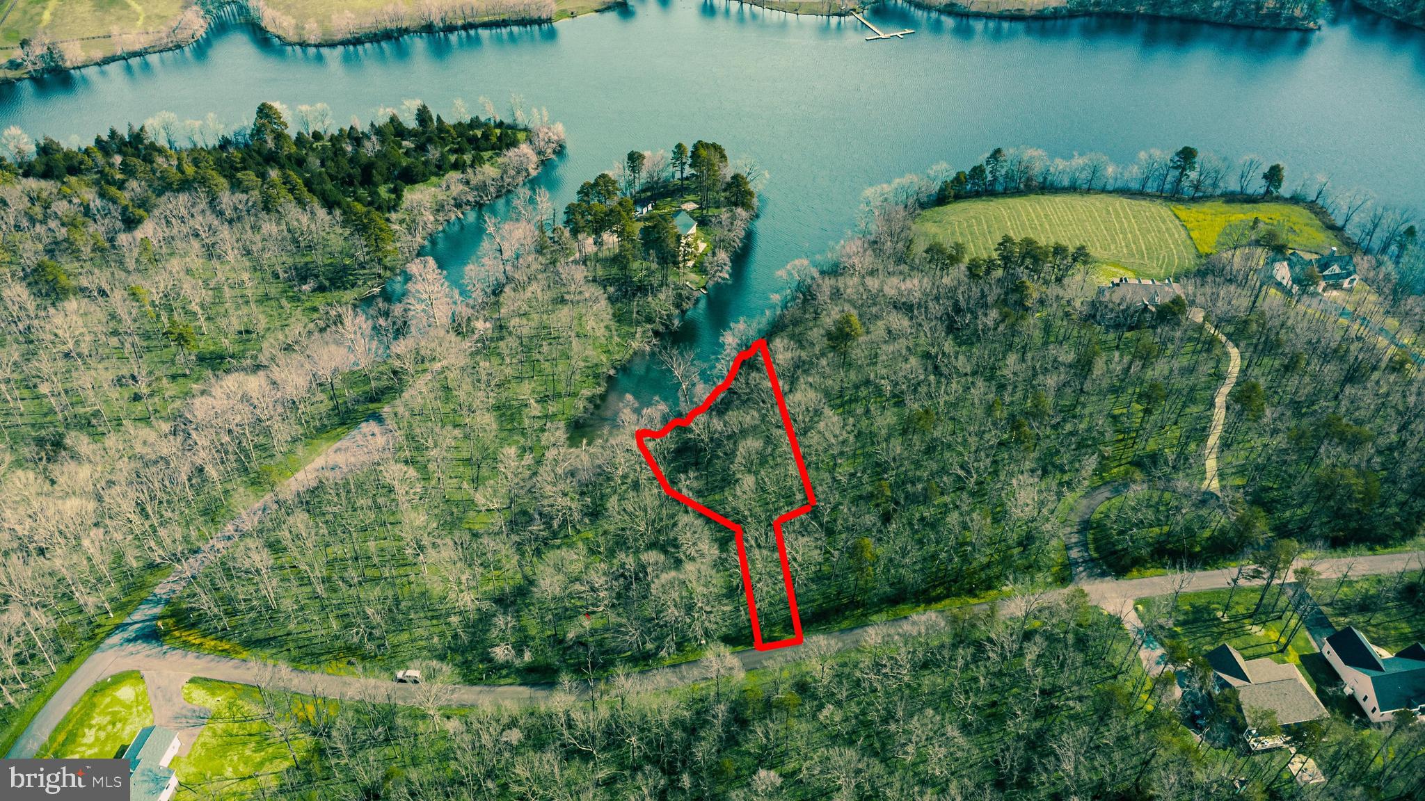 an aerial view of a house with a yard and lake view