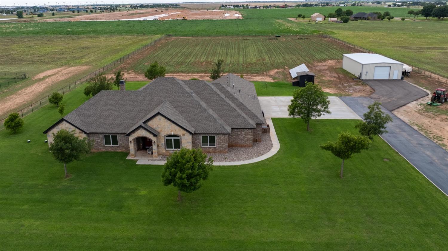 an aerial view of a house with a garden and lake view