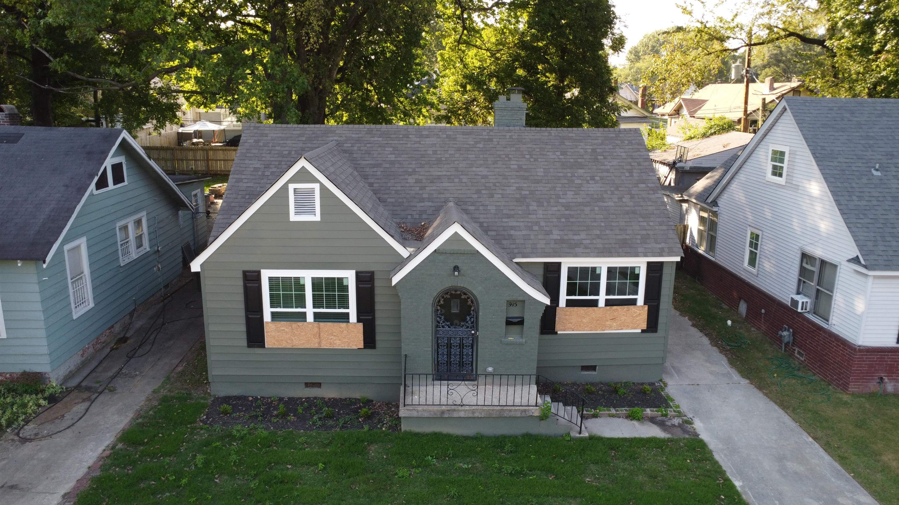 a front view of a house with a yard and trees