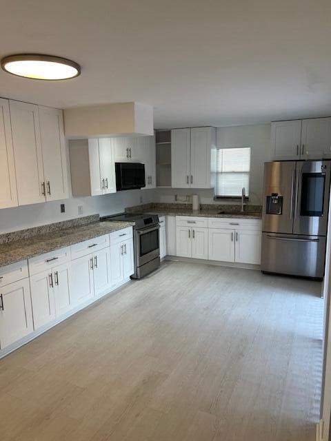 a large kitchen with cabinets and stainless steel appliances