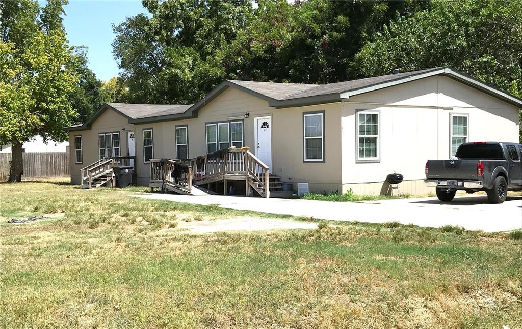 a front view of house with yard and trees around