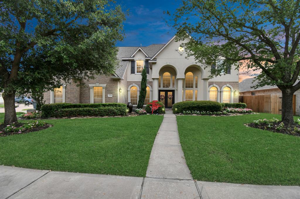 a front view of a house with a garden and plants