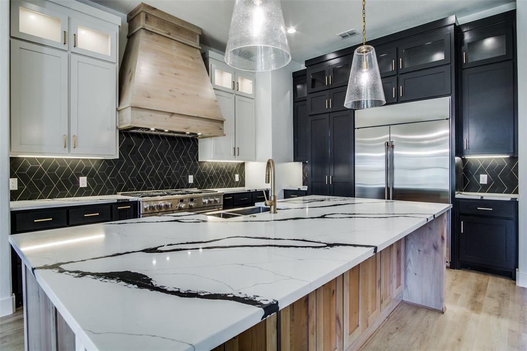 a kitchen with kitchen island granite countertop a sink stove and refrigerator