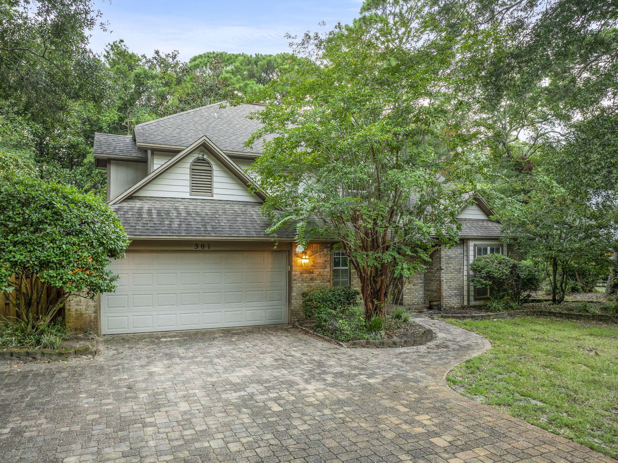 a front view of a house with a yard and trees