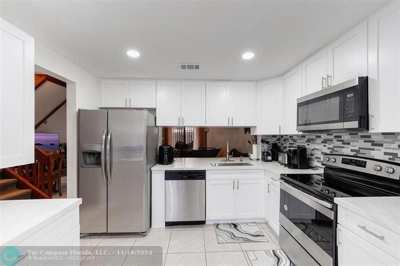 a kitchen with stainless steel appliances a refrigerator stove microwave and sink