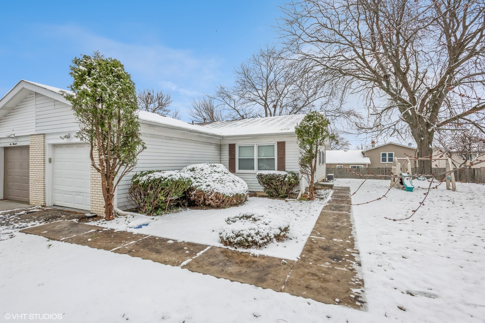 a front view of a house with a yard covered in snow