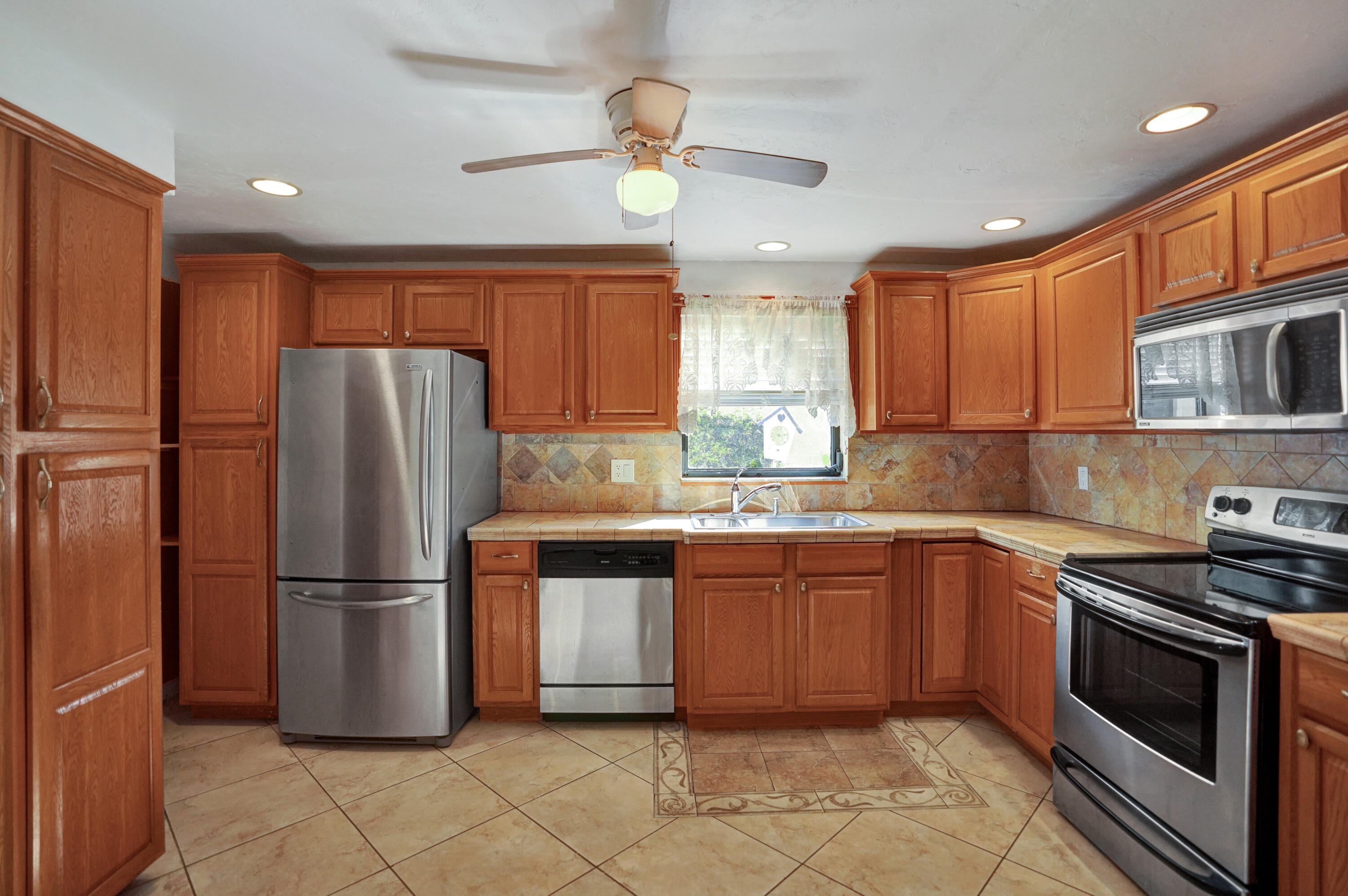 a kitchen with stainless steel appliances granite countertop a refrigerator stove a sink and dishwasher