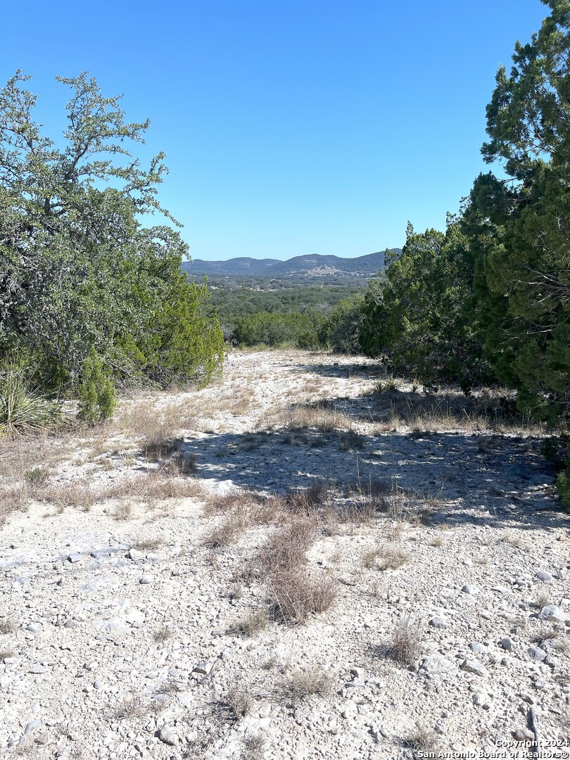 a view of dirt road with a building in the background