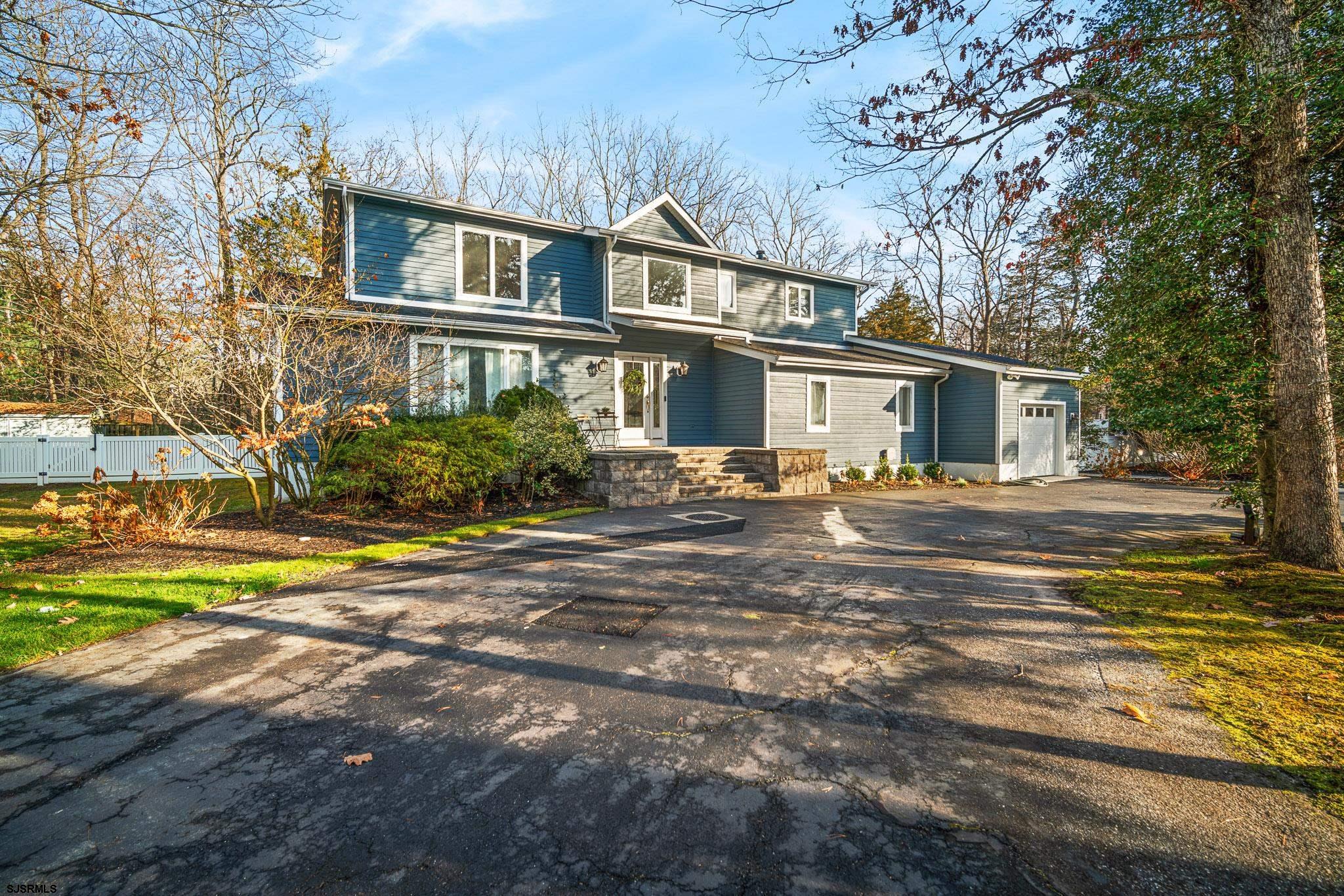 a front view of residential houses with yard and trees