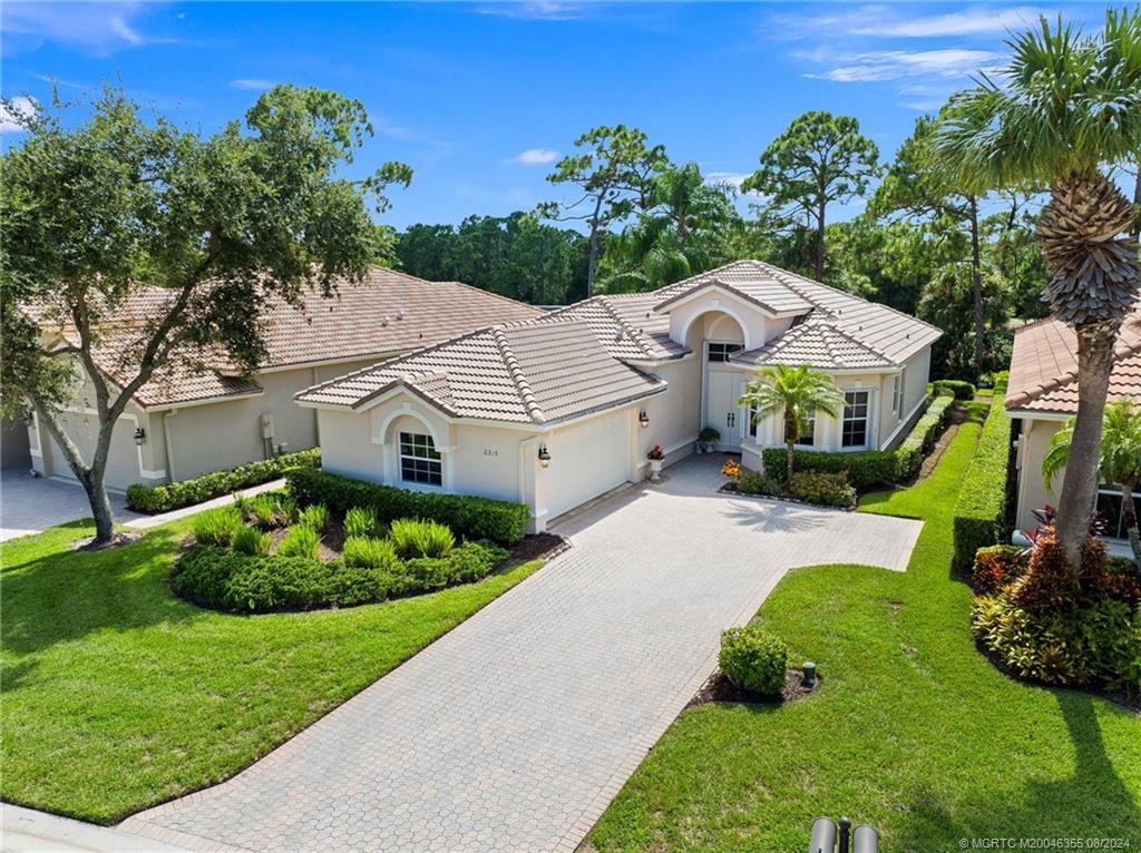 a aerial view of a house with a yard and a large tree