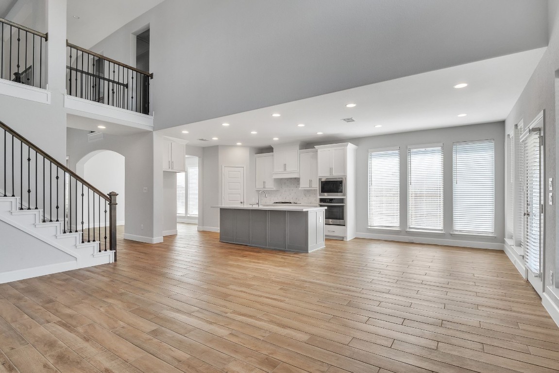 a view of an entryway with wooden floor and a kitchen