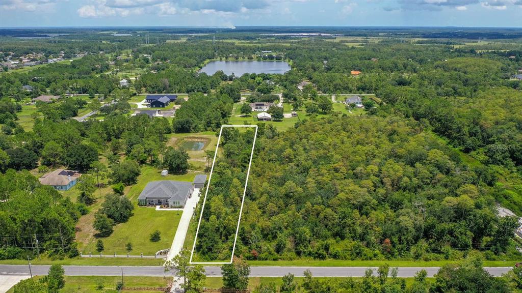 an aerial view of residential houses with outdoor space and trees