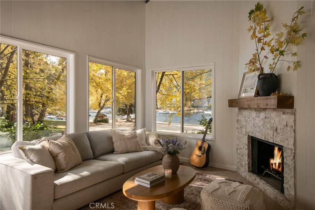 a living room with furniture a fireplace and a floor to ceiling window