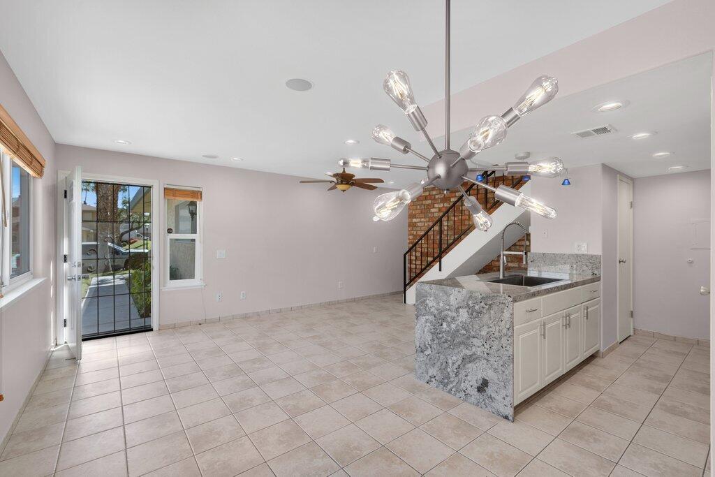 a kitchen with granite countertop a sink a stove top oven and cabinets