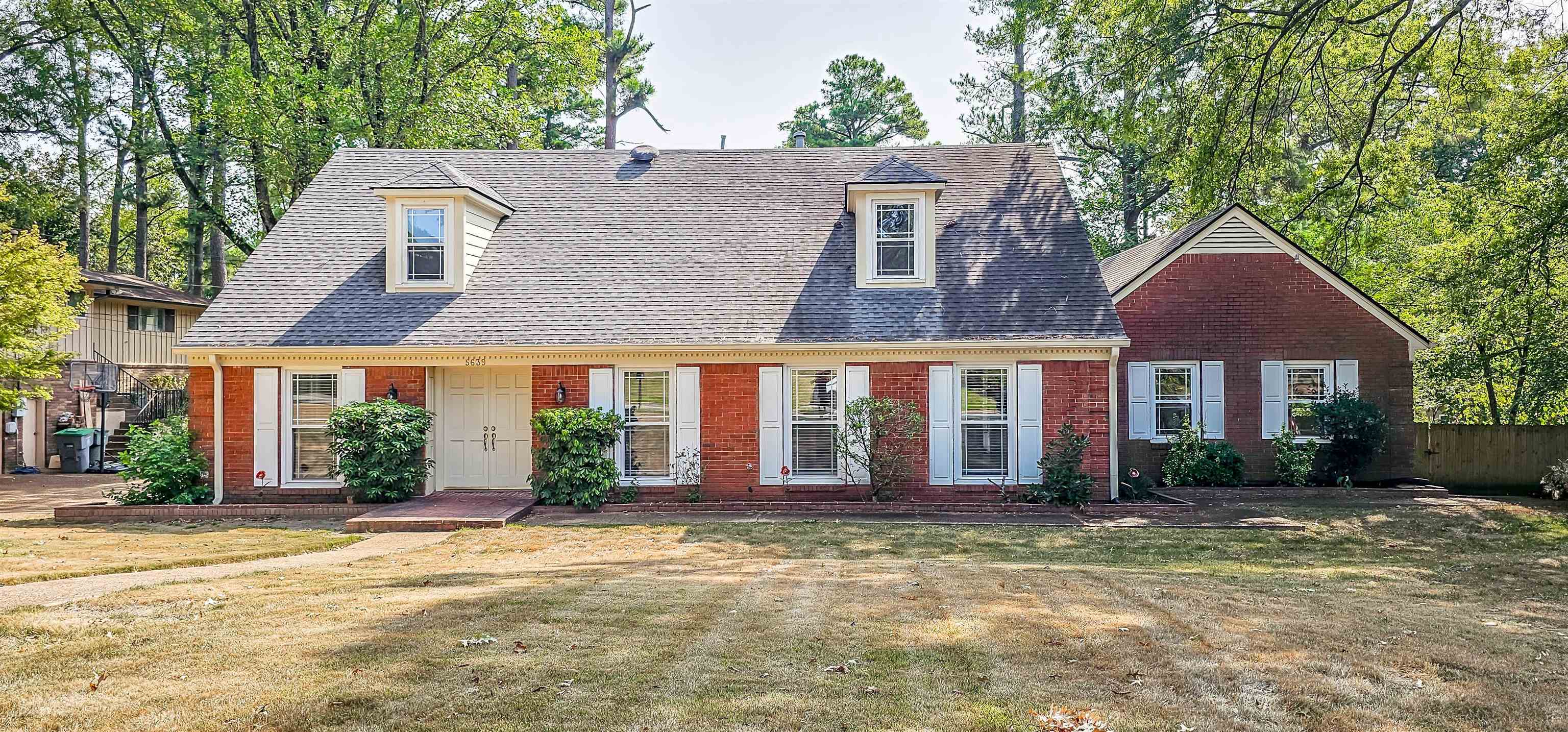 front view of a brick house with a yard