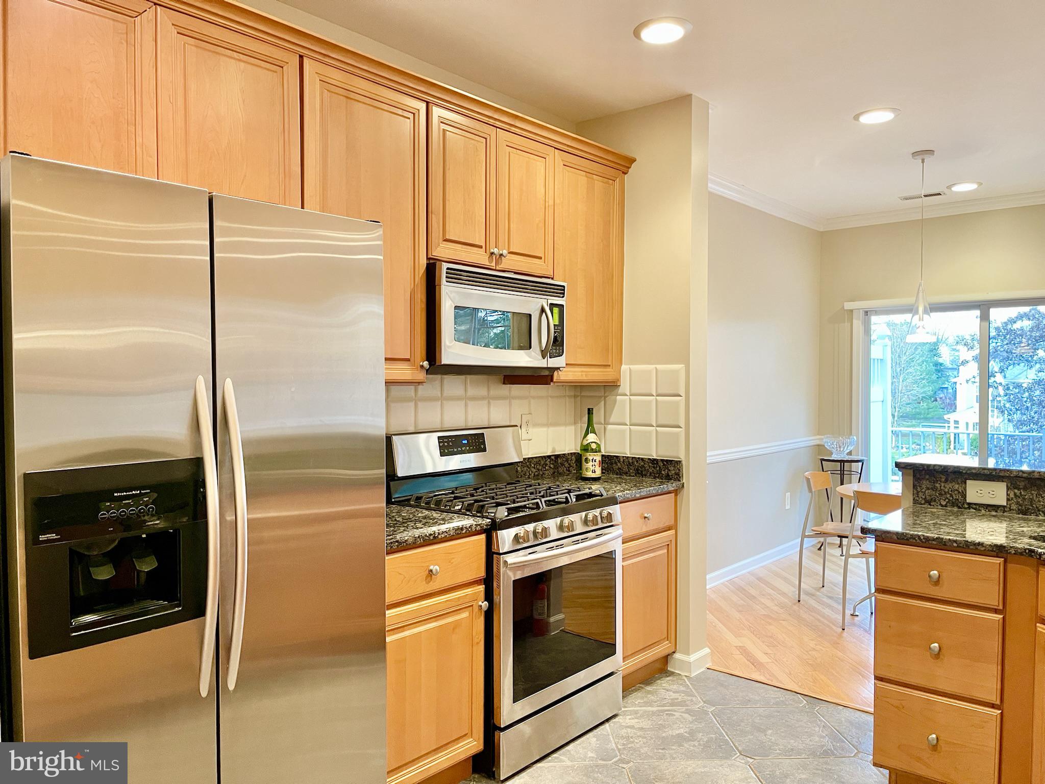 a kitchen with stainless steel appliances granite countertop a refrigerator stove and sink