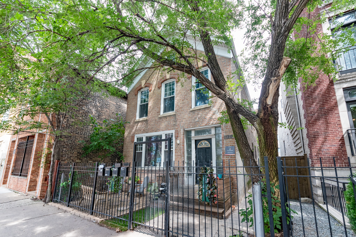 a front view of a house with a tree