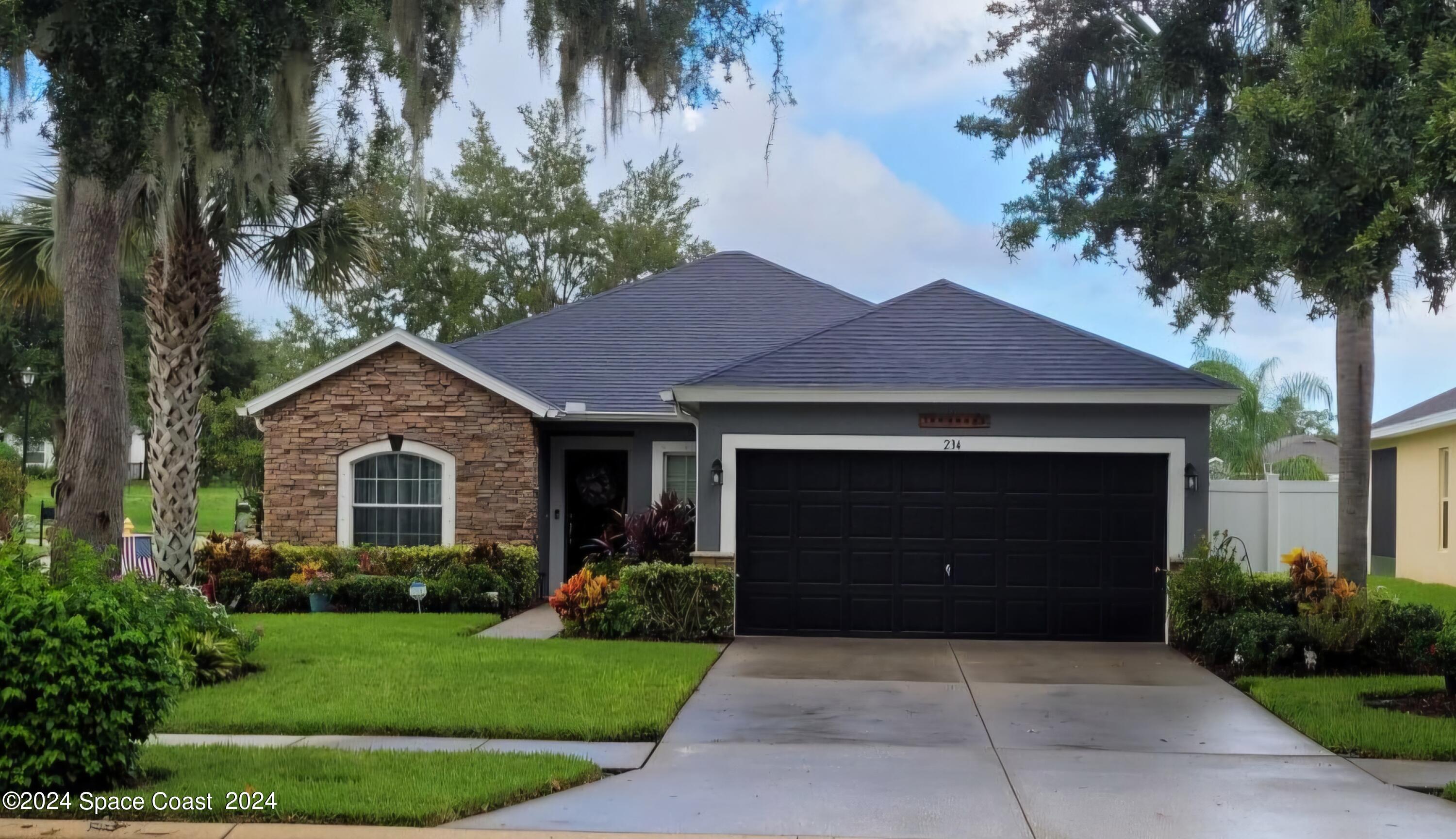 a front view of a house with a garden