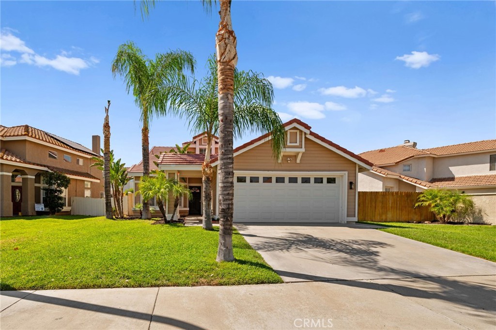 a view of a big house with a big yard and palm trees