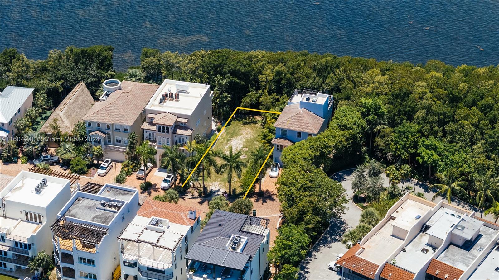 an aerial view of a house with a yard and lake view