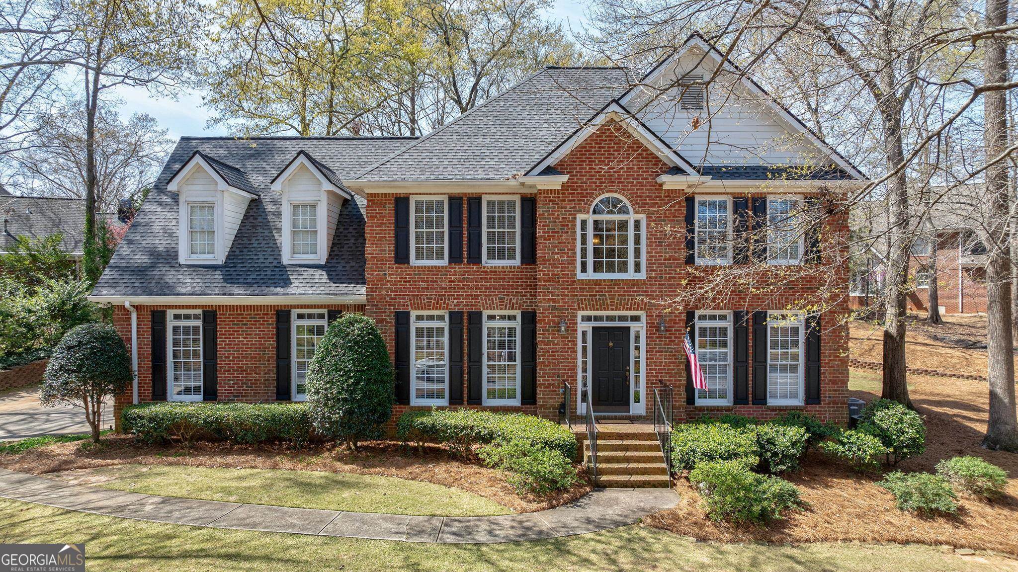 a front view of a house with garden and garage