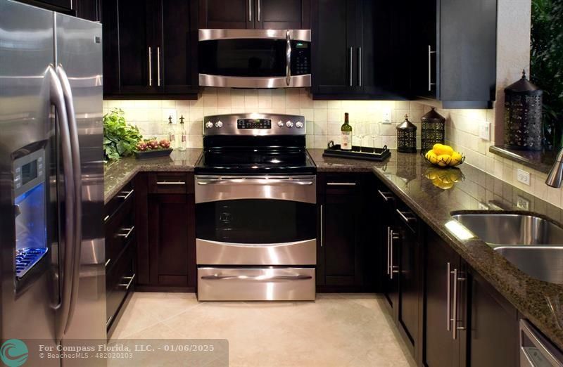 a kitchen with stainless steel appliances a stove a sink and a microwave