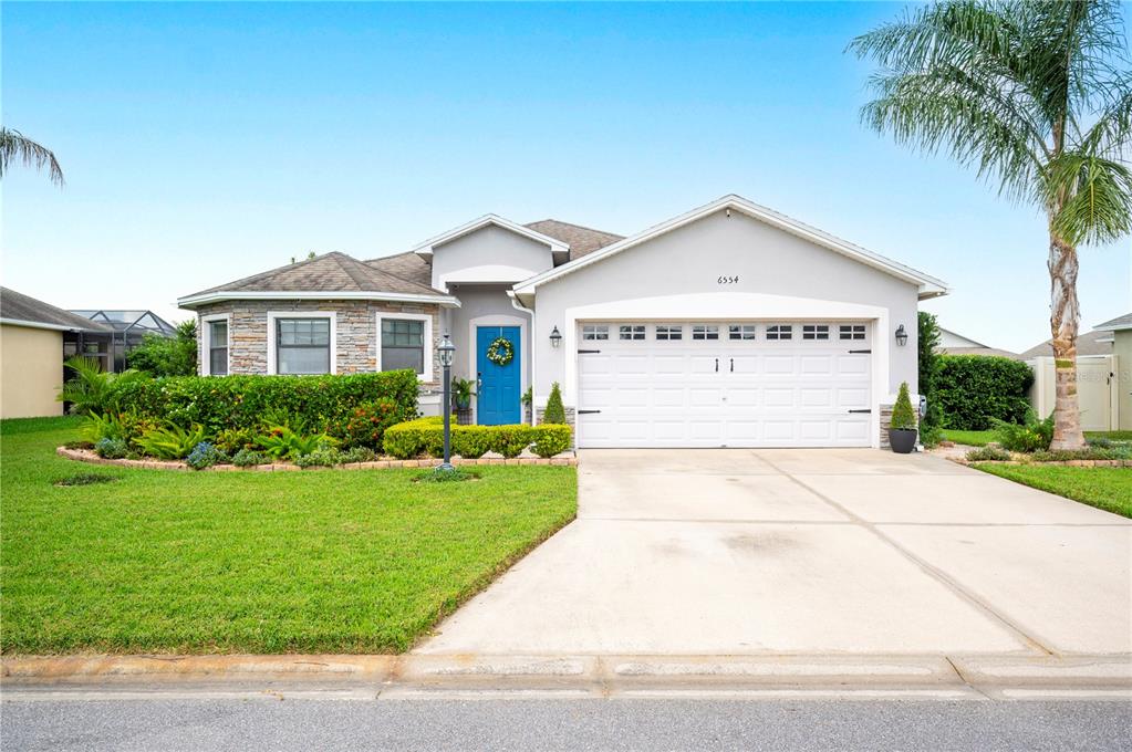 a view of a house with a yard and palm trees