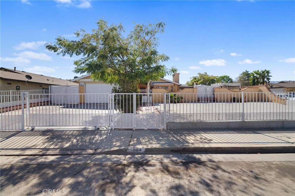 a view of a gate with a small yard and wooden fence