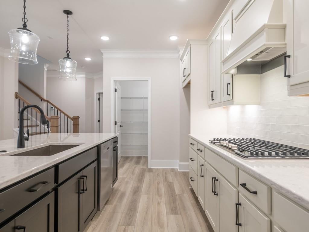 a kitchen with granite countertop a sink stove and cabinets