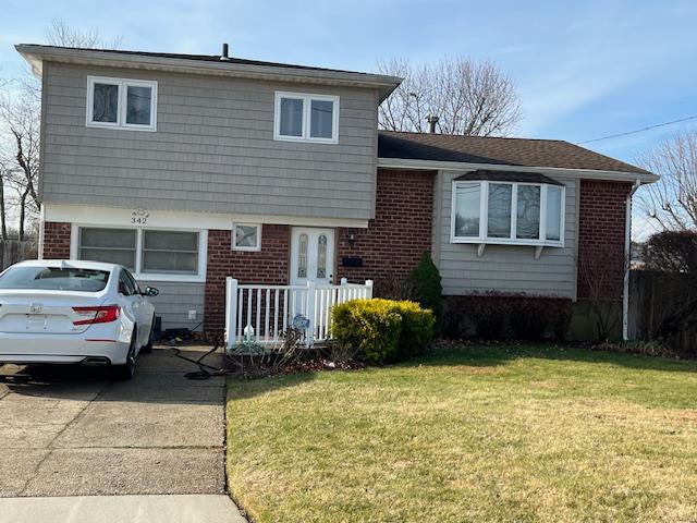 Split level home with a front lawn