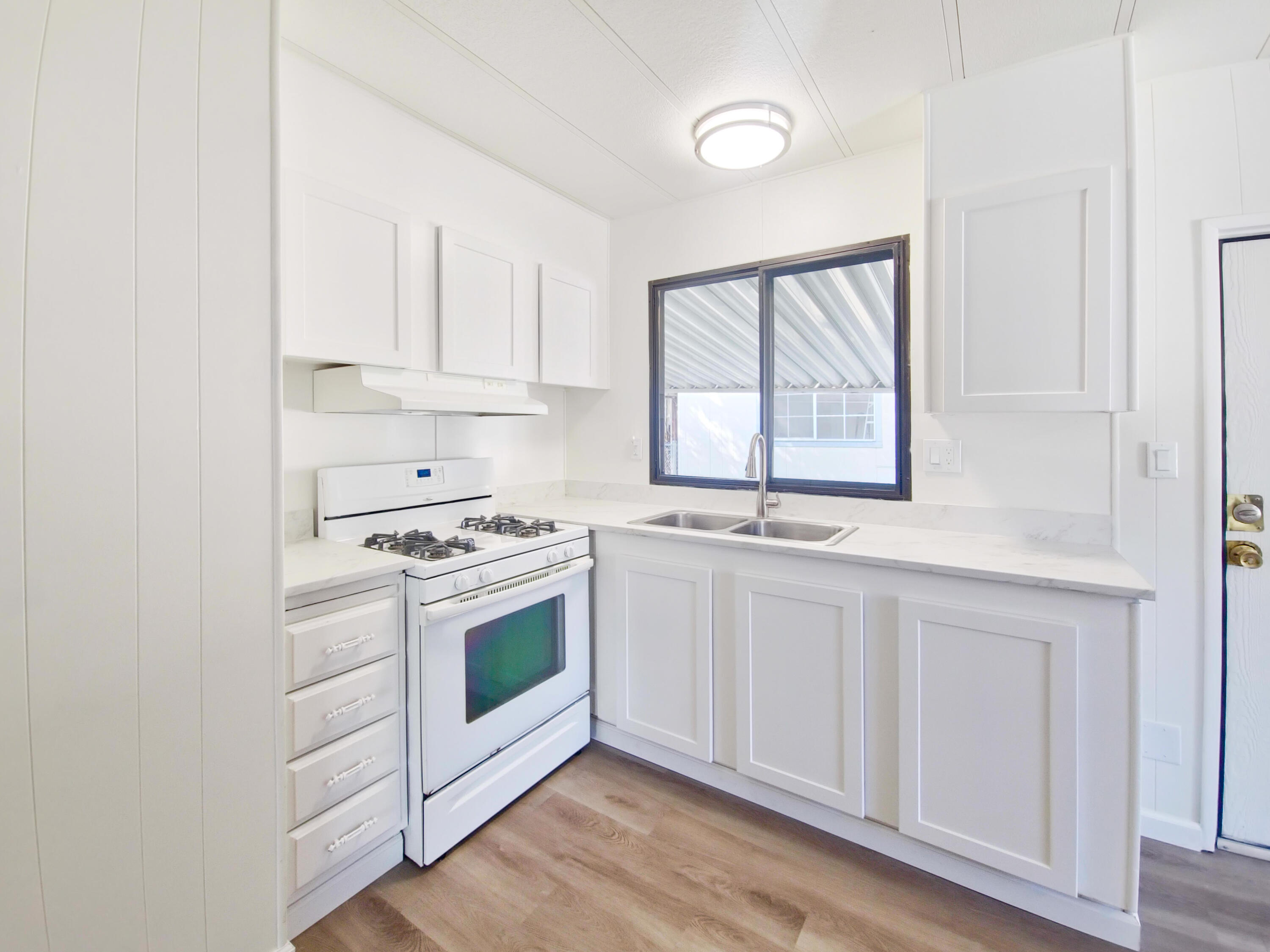 a kitchen with granite countertop white cabinets and white appliances