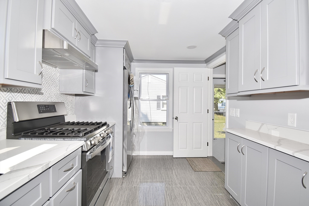 a kitchen with granite countertop a stove and a refrigerator