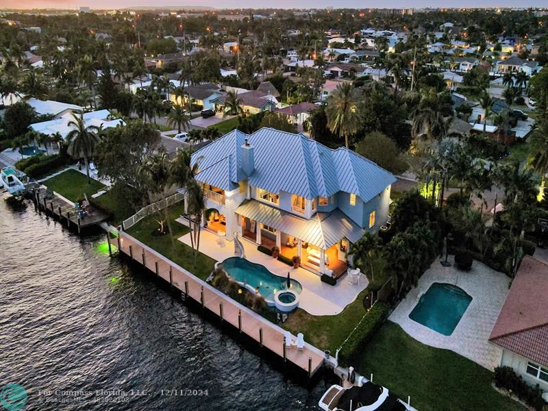 an aerial view of a house with a swimming pool outdoor seating