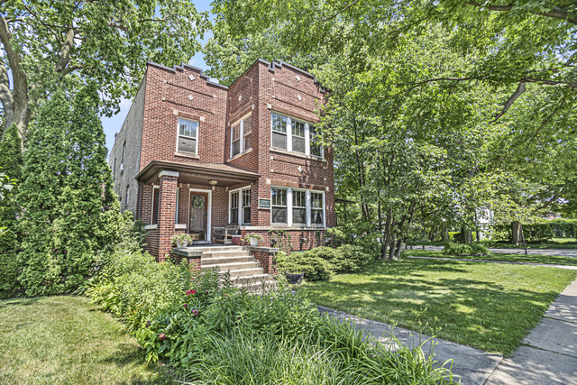 a front view of a residential apartment building with a yard