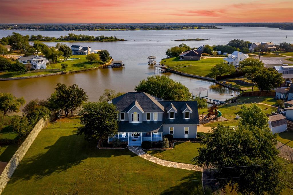 an aerial view of residential houses with outdoor space and lake view