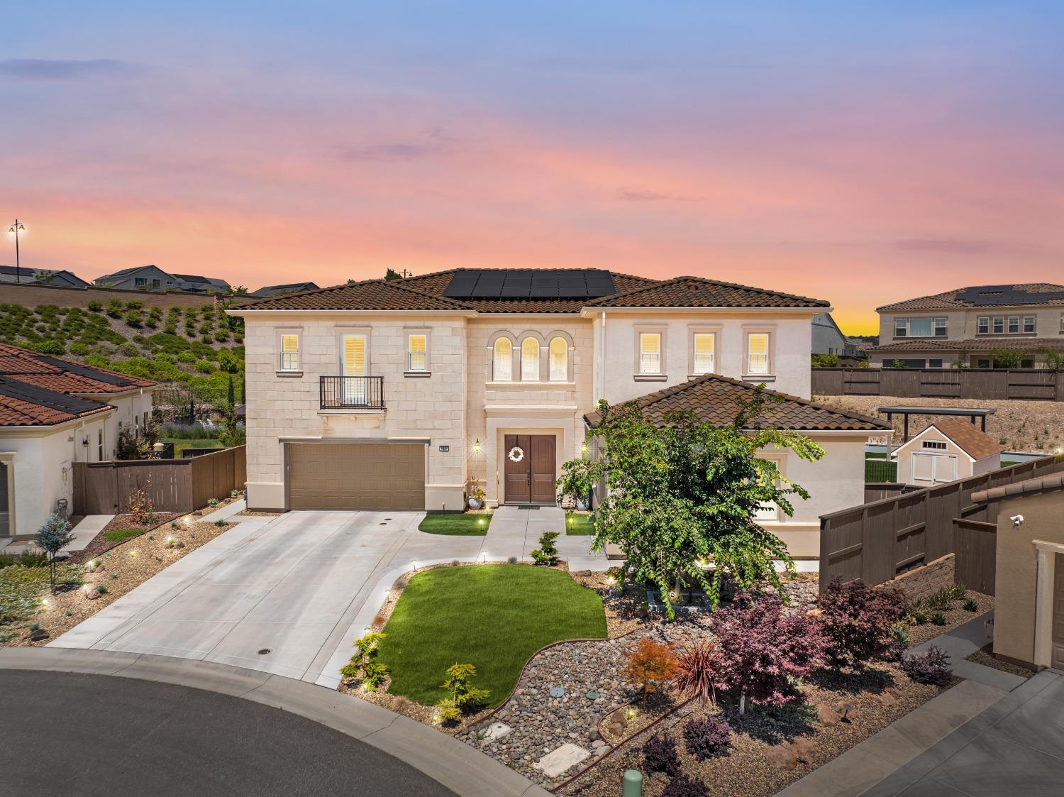 a front view of a house with a yard and mountain view