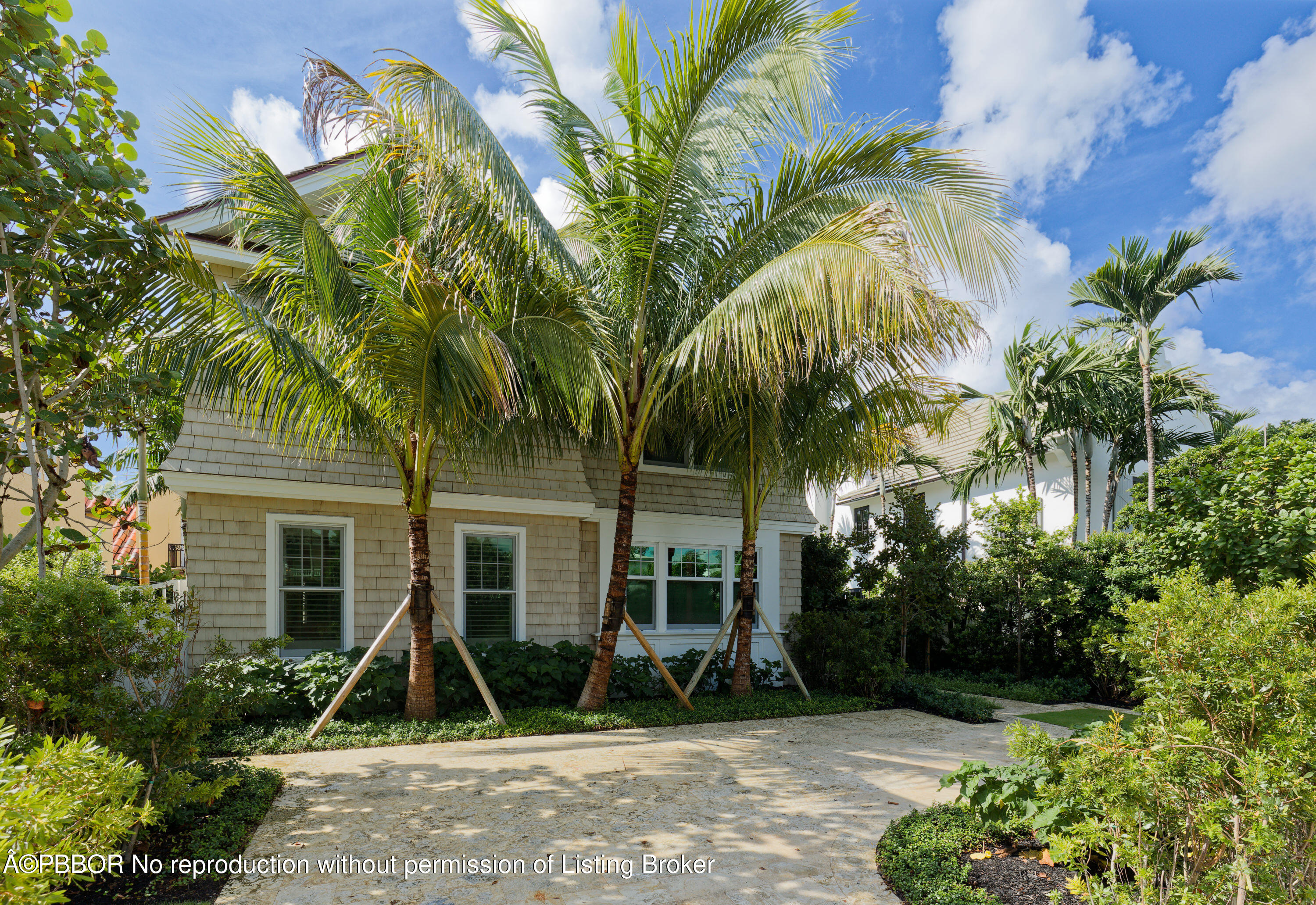 front view of a house with a yard and potted plants