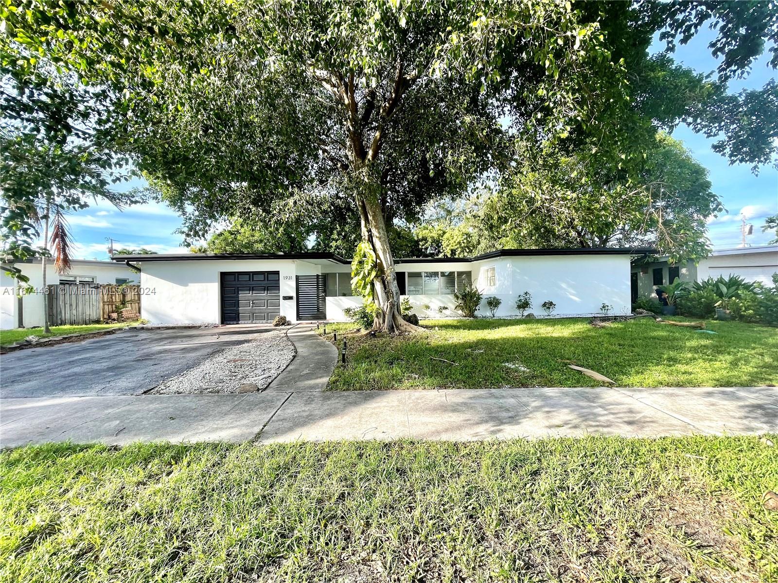 a view of a house with backyard and a tree